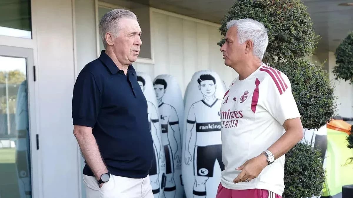 Two football managers conversing at training facility Two football managers conversing at training facility