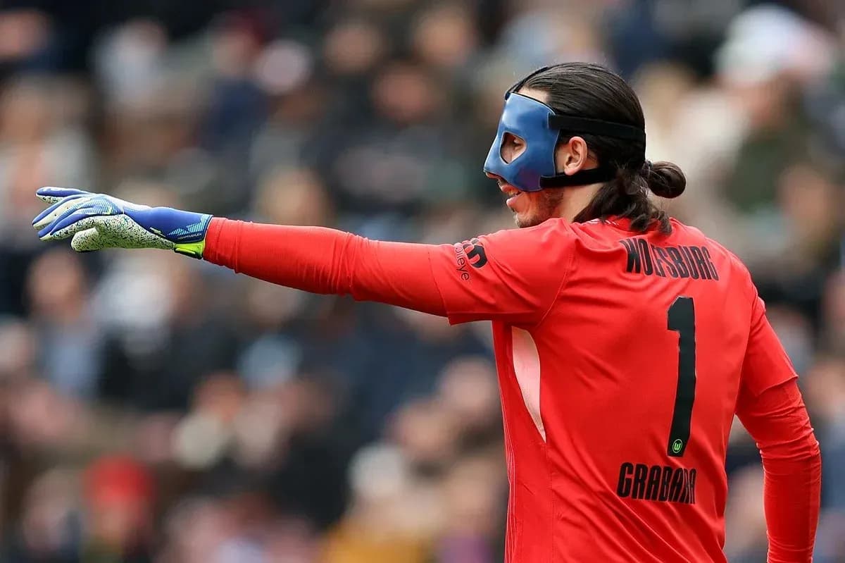 Goalkeeper in red kit directing play on field Goalkeeper in red kit directing play on field