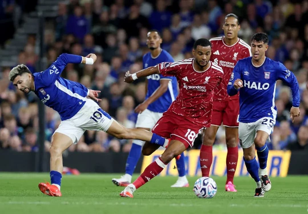 Ipswich player challenges Liverpool defender for the ball Ipswich player challenges Liverpool defender for the ball