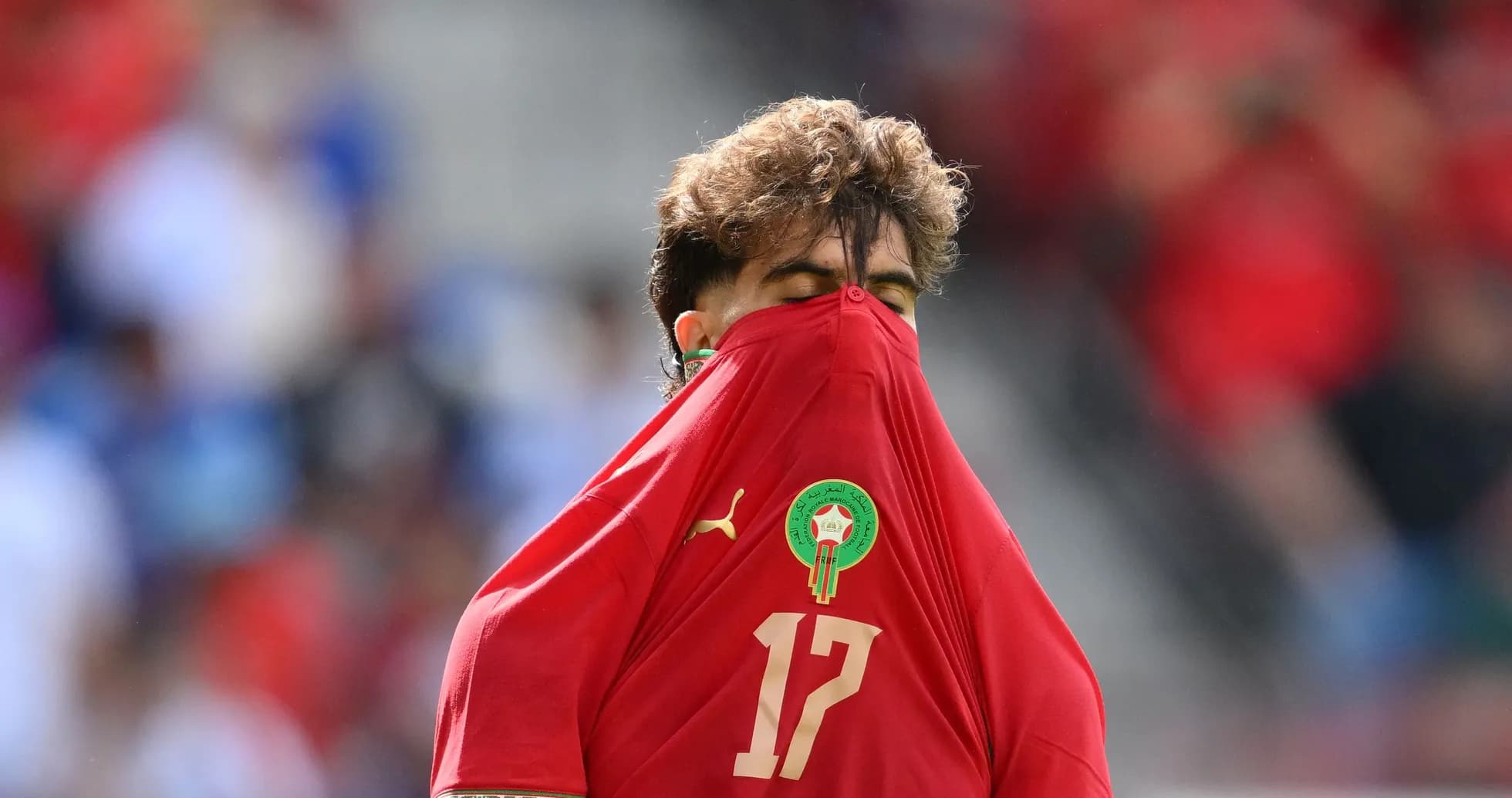 Player in red jersey pulling shirt over face Player in red jersey pulling shirt over face