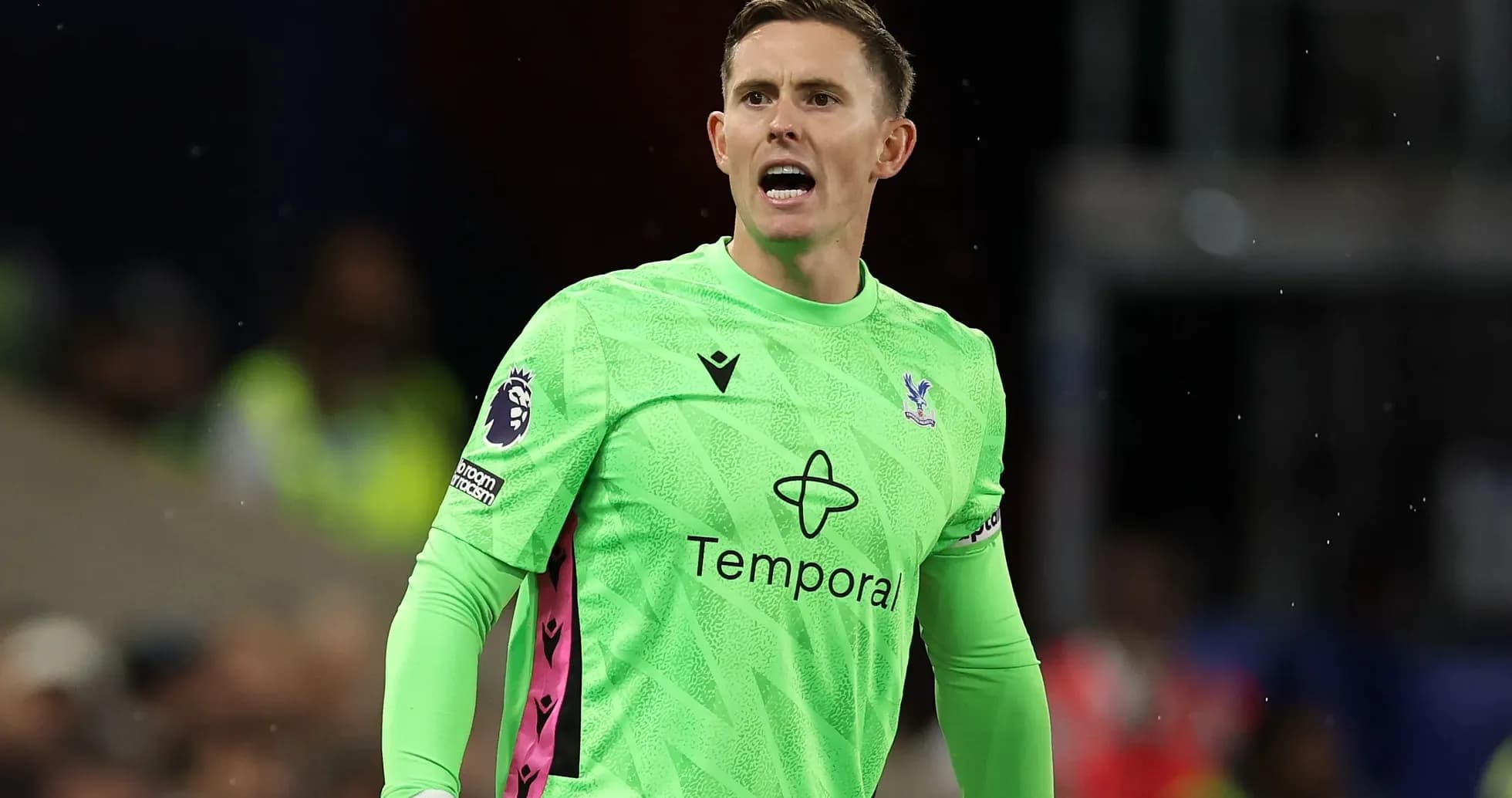 Goalkeeper in green kit directing teammates during match Goalkeeper in green kit directing teammates during match