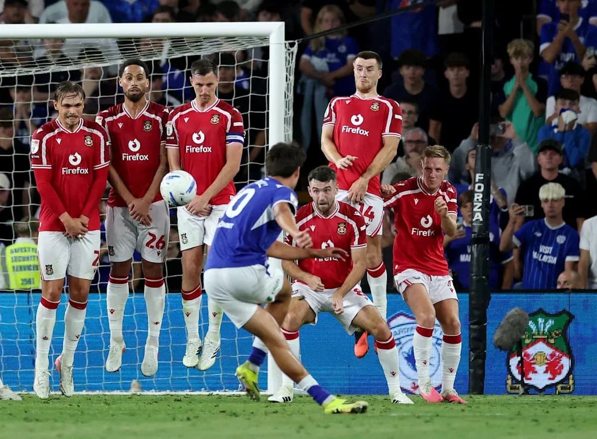 Player taking a free kick while defenders prepare Player taking a free kick while defenders prepare