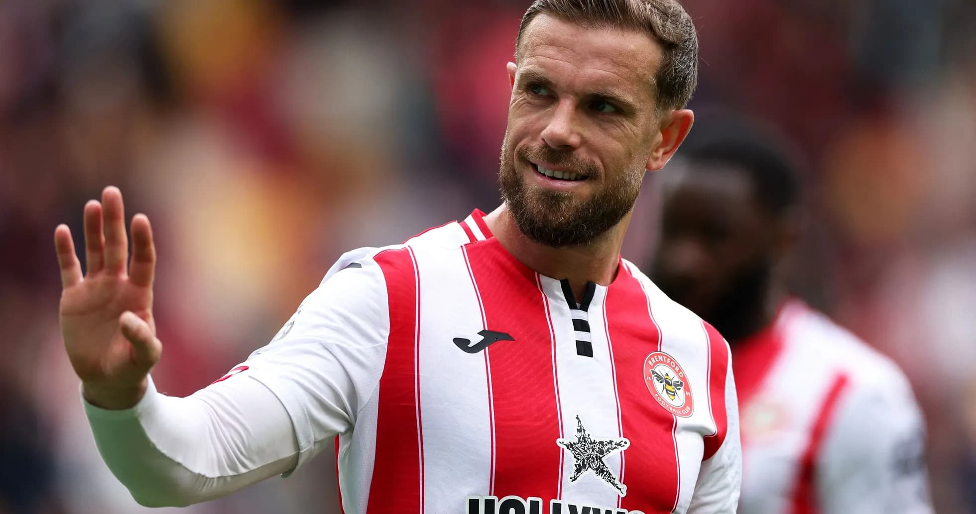 Brentford player waving during a match Brentford player waving during a match