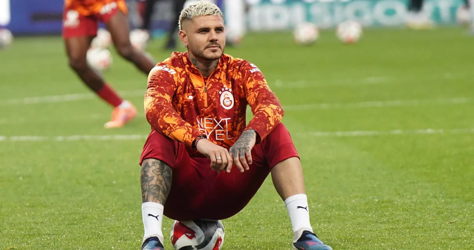 Player sitting on a soccer ball during warm-up Player sitting on a soccer ball during warm-up