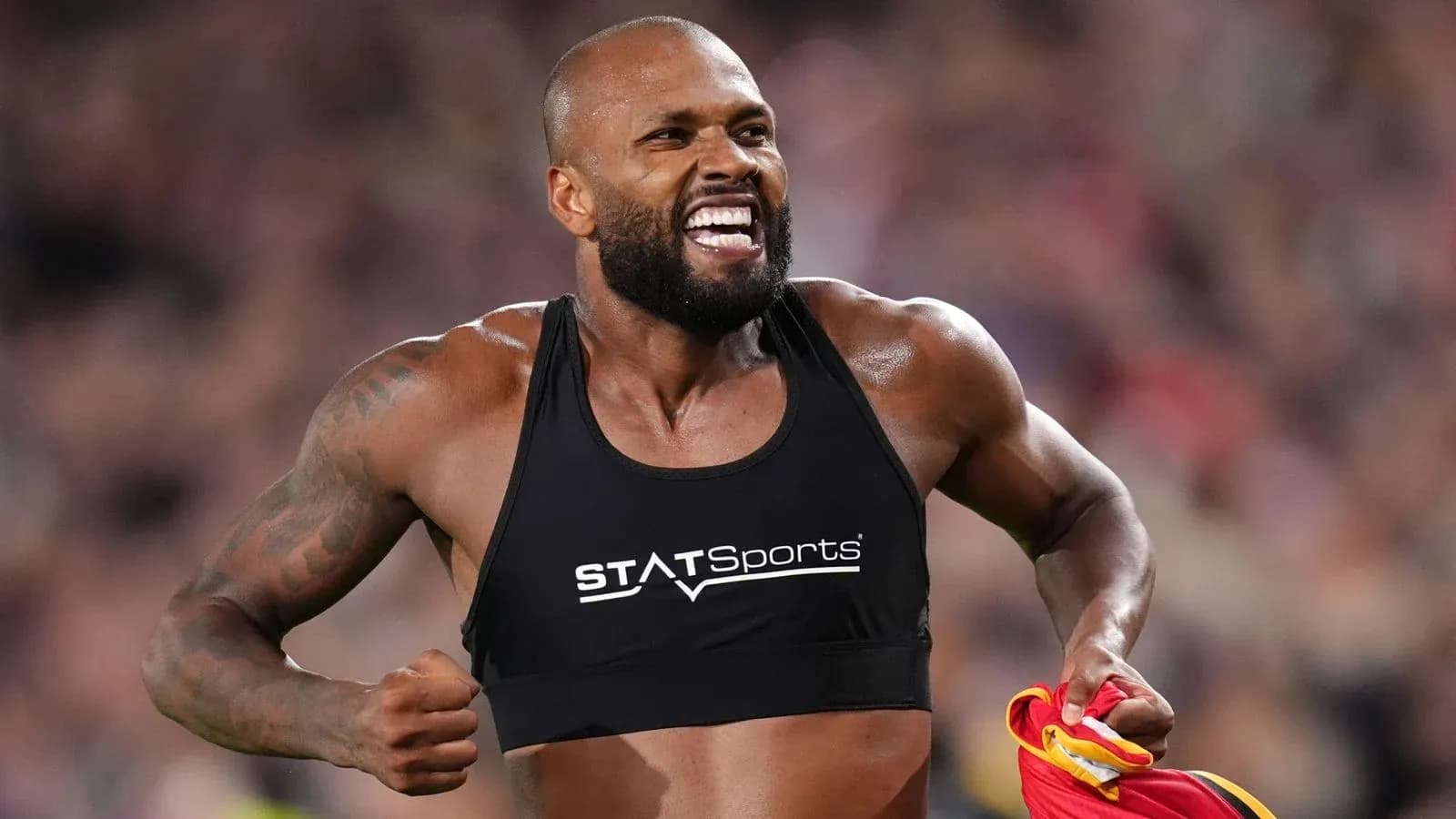 Athlete celebrating with jersey after performance Athlete celebrating with jersey after performance