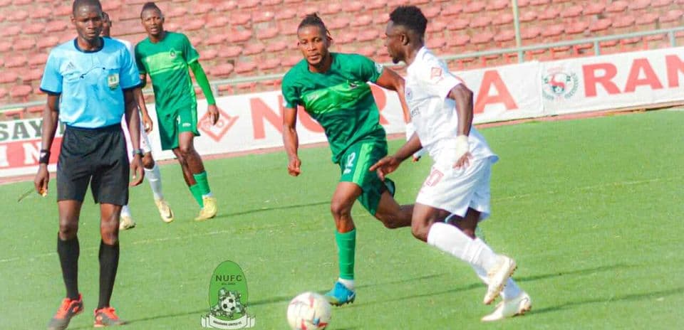 Players competing for the ball during NPFL match Players competing for the ball during NPFL match