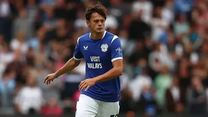 Player in blue kit running on the pitch Player in blue kit running on the pitch