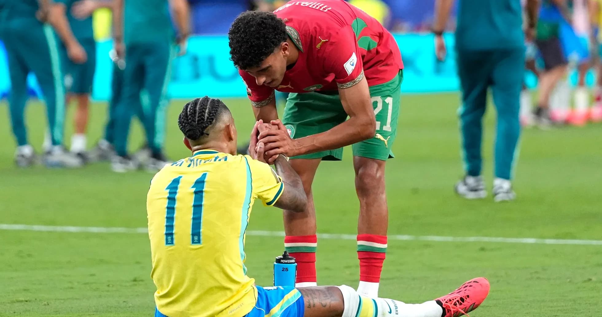 Moroccan player helping Brazilian player on field Moroccan player helping Brazilian player on field