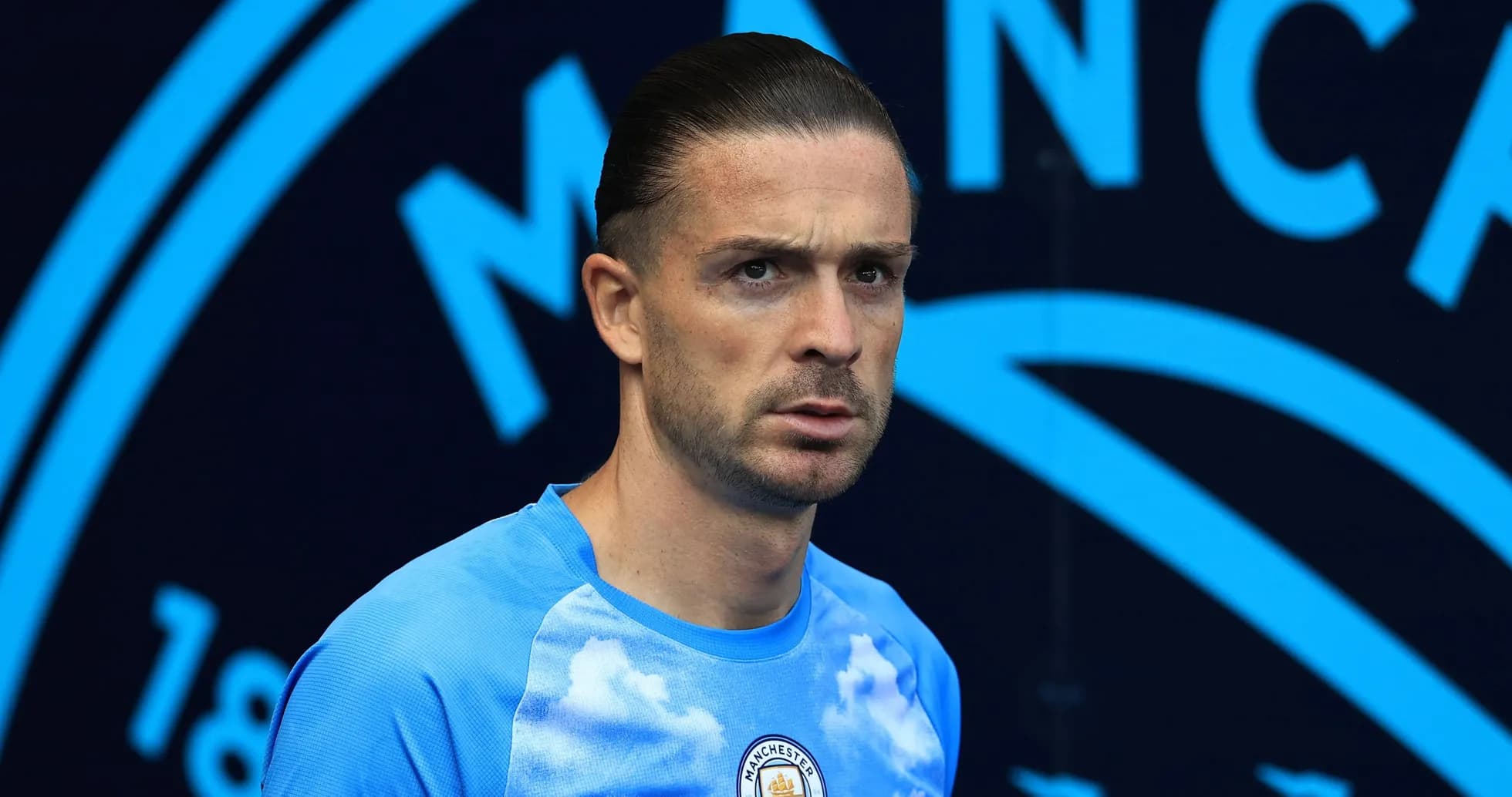 Player in Manchester City kit at stadium entrance Player in Manchester City kit at stadium entrance