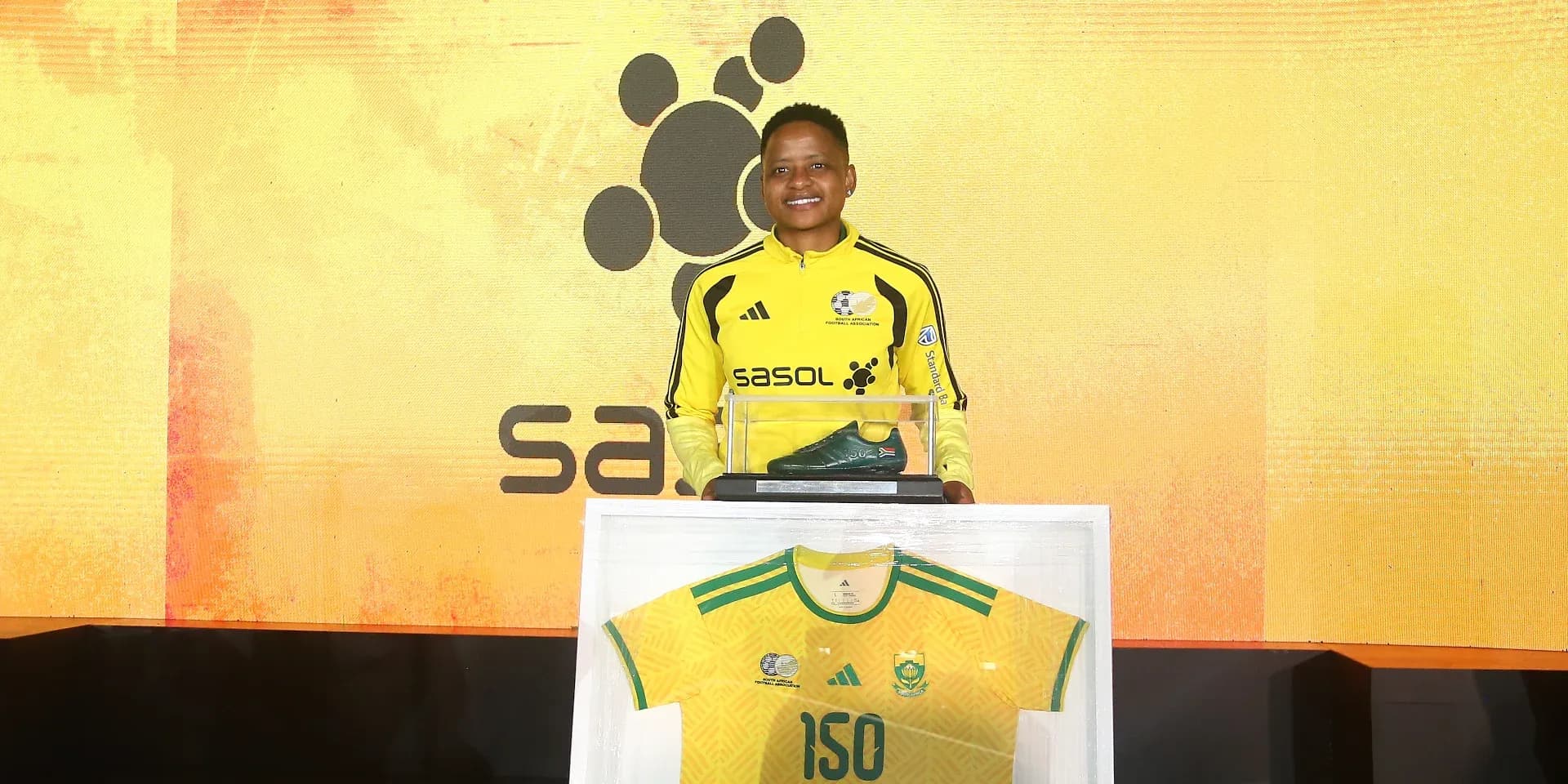 Player posing with jersey and soccer boots at event Player posing with jersey and soccer boots at event
