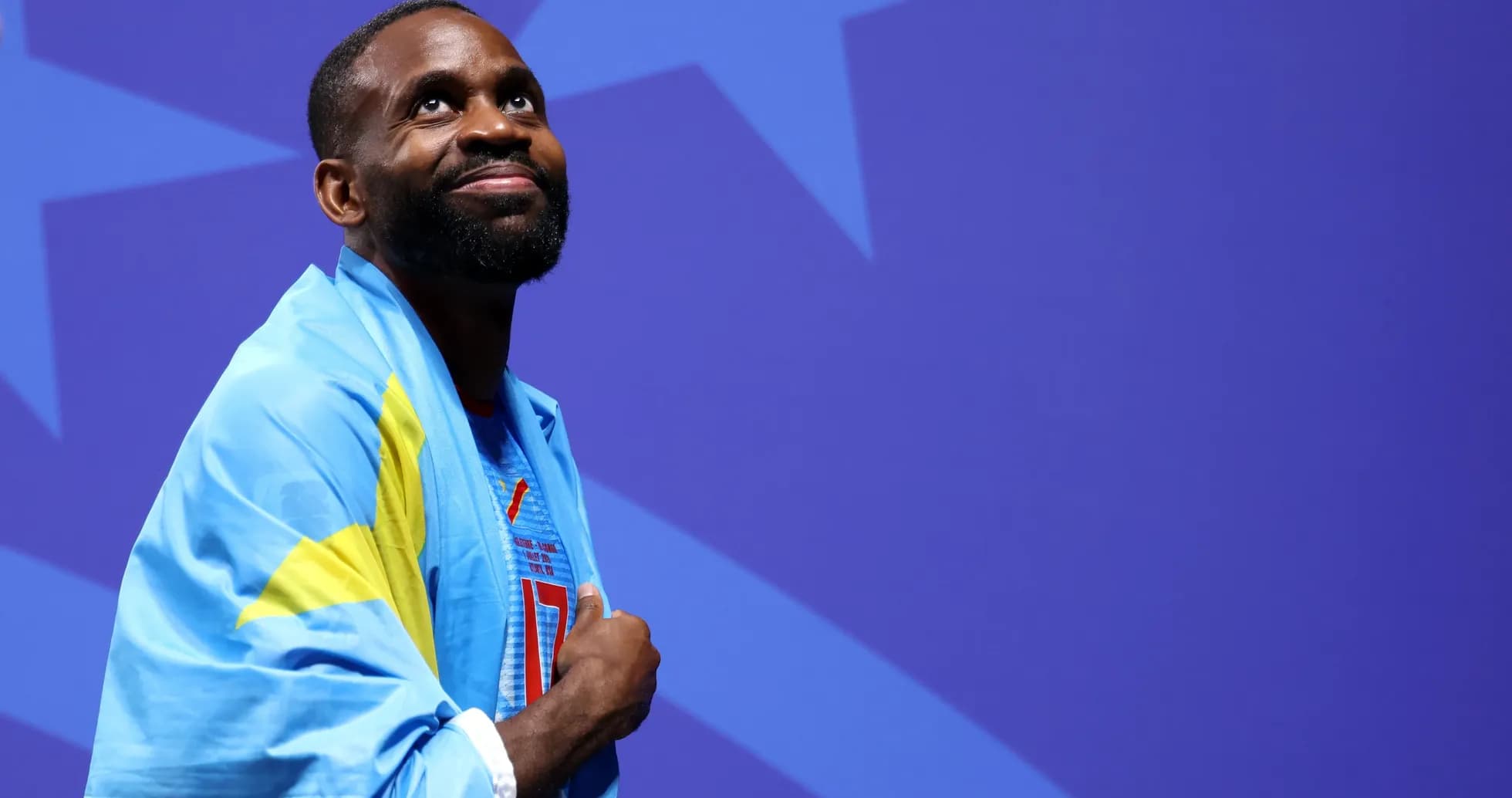 Athlete wearing a flag, looking upwards Athlete wearing a flag, looking upwards