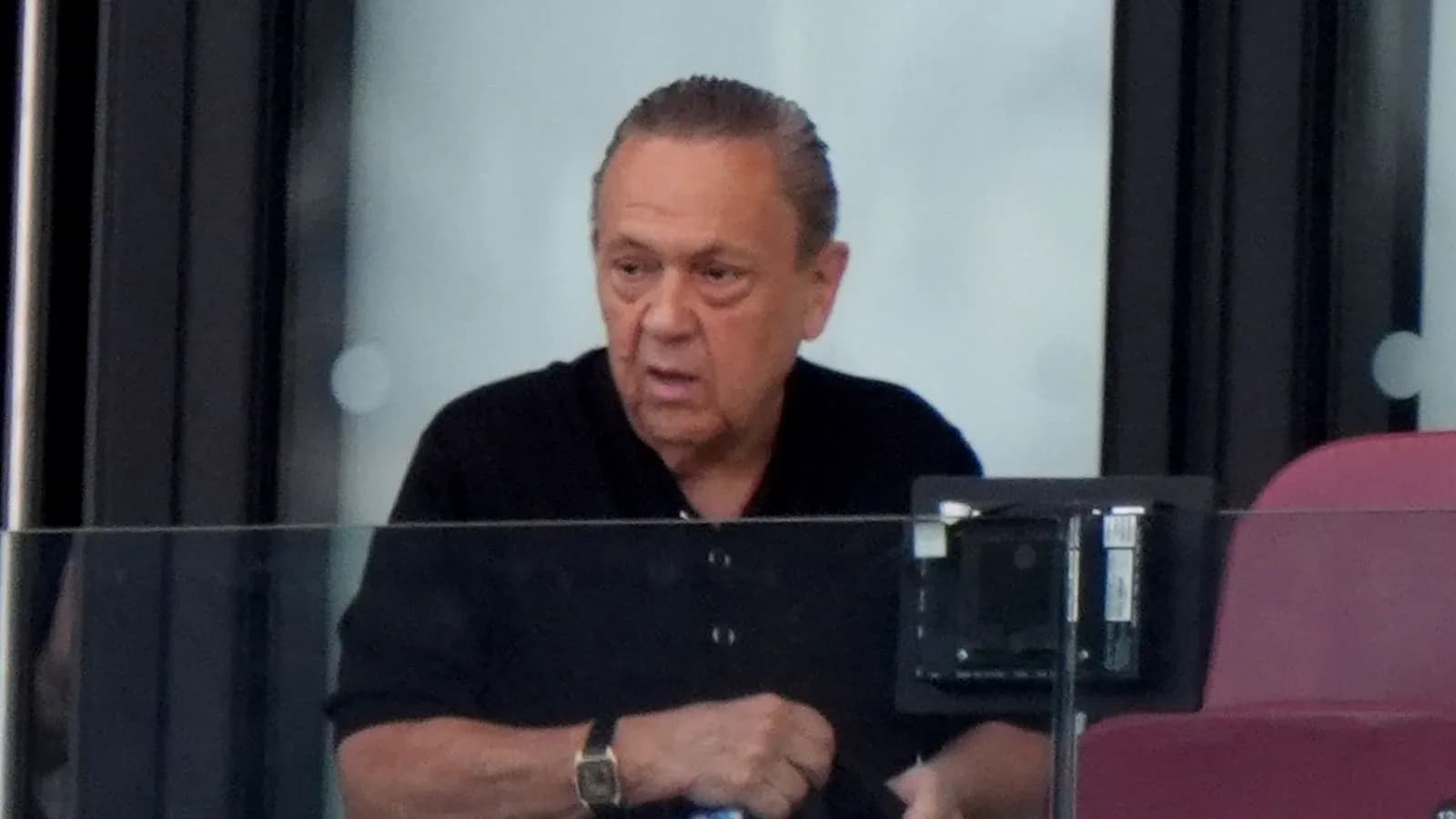 Man observing from a luxury box at stadium Man observing from a luxury box at stadium