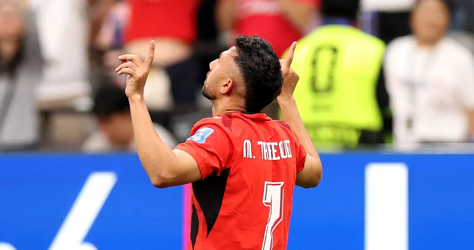 Player celebrating goal with arms raised in stadium Player celebrating goal with arms raised in stadium