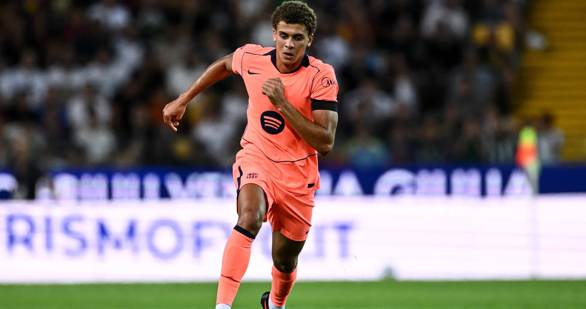 Player sprinting in bright pink kit during match Player sprinting in bright pink kit during match