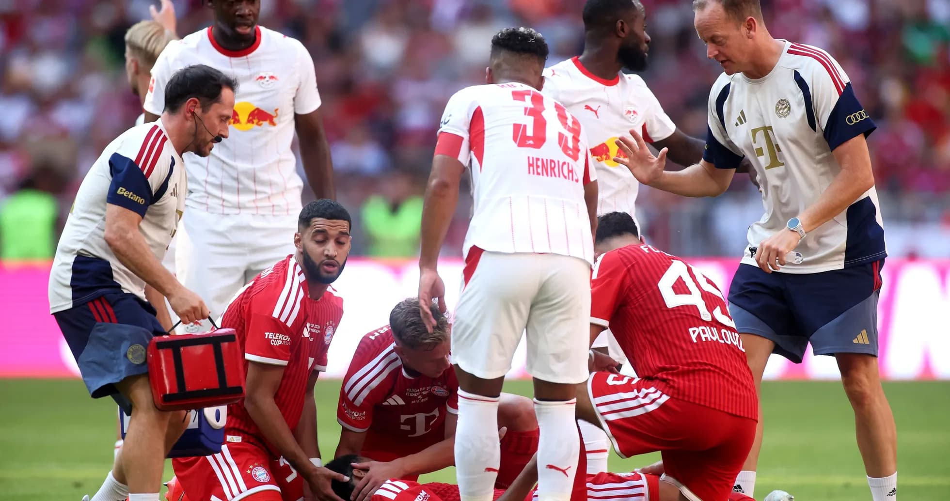 Players attending to an injured teammate on the field Players attending to an injured teammate on the field
