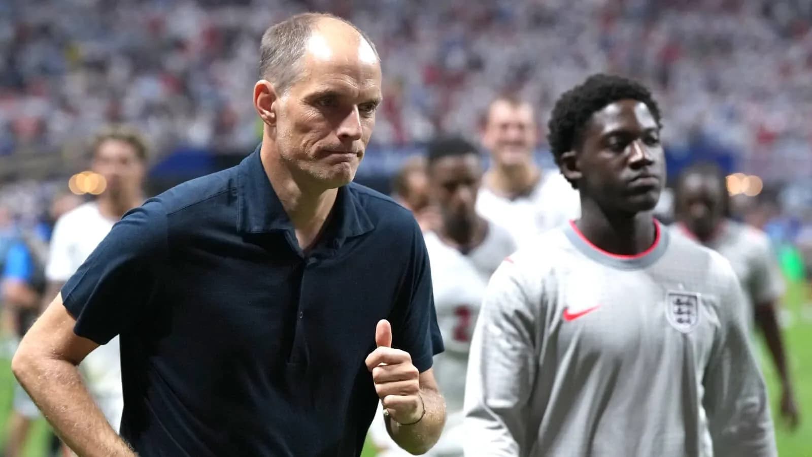 Manager walking off field with players behind Manager walking off field with players behind