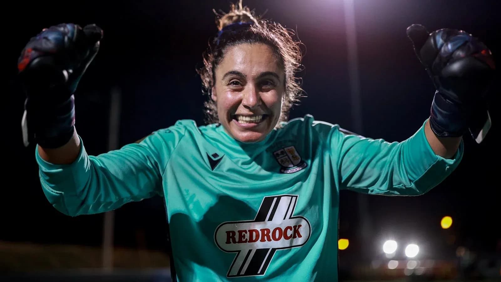 Goalkeeper celebrating with raised fists at night Goalkeeper celebrating with raised fists at night