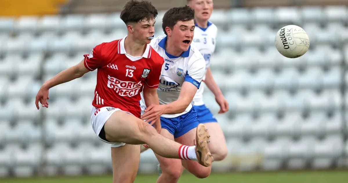 Player kicking the ball while being challenged by opponent Player kicking the ball while being challenged by opponent