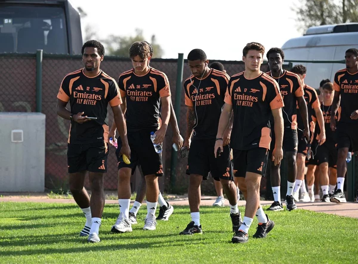 Arsenal players walking to training session on pitch Arsenal players walking to training session on pitch