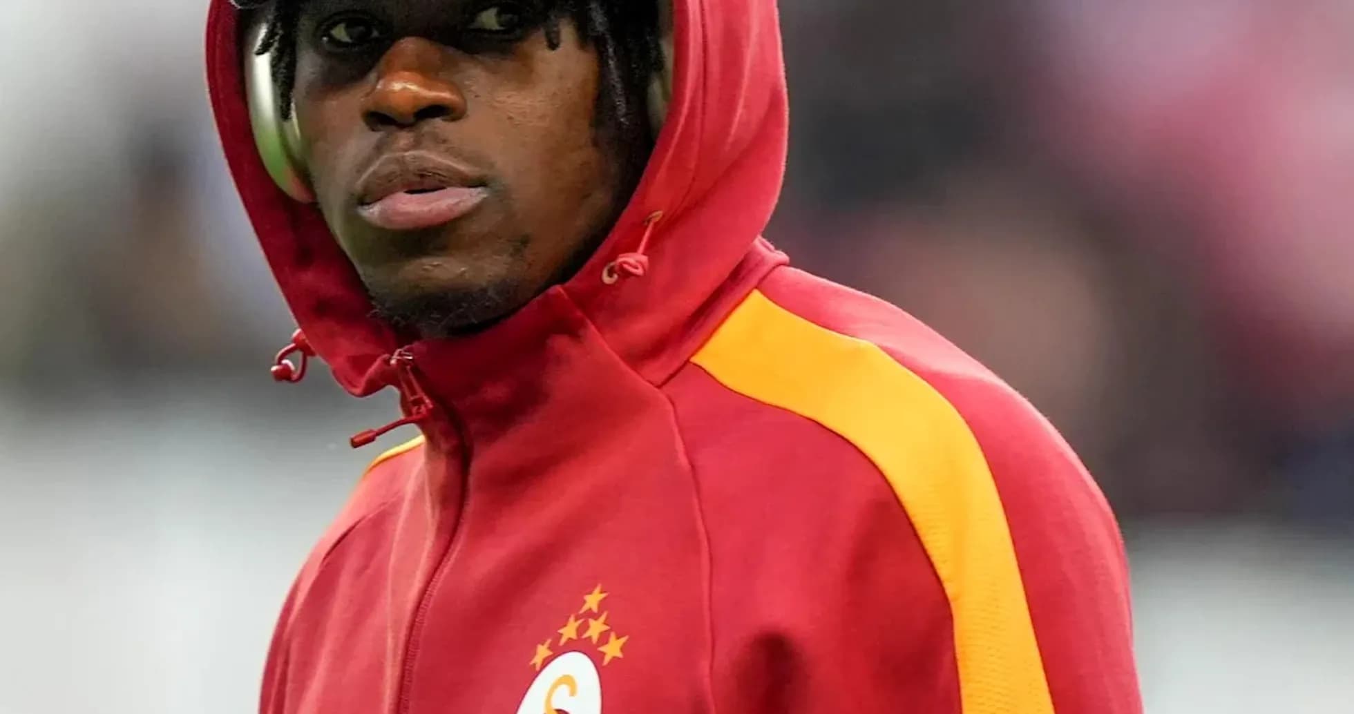 Player in red jacket with hood before match Player in red jacket with hood before match