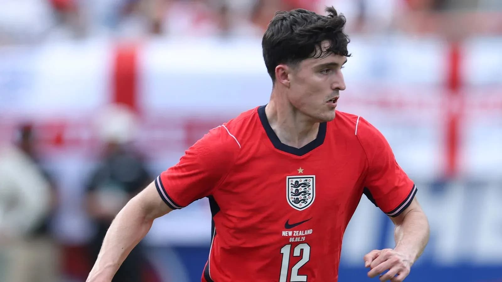Player in red England jersey running on field Player in red England jersey running on field