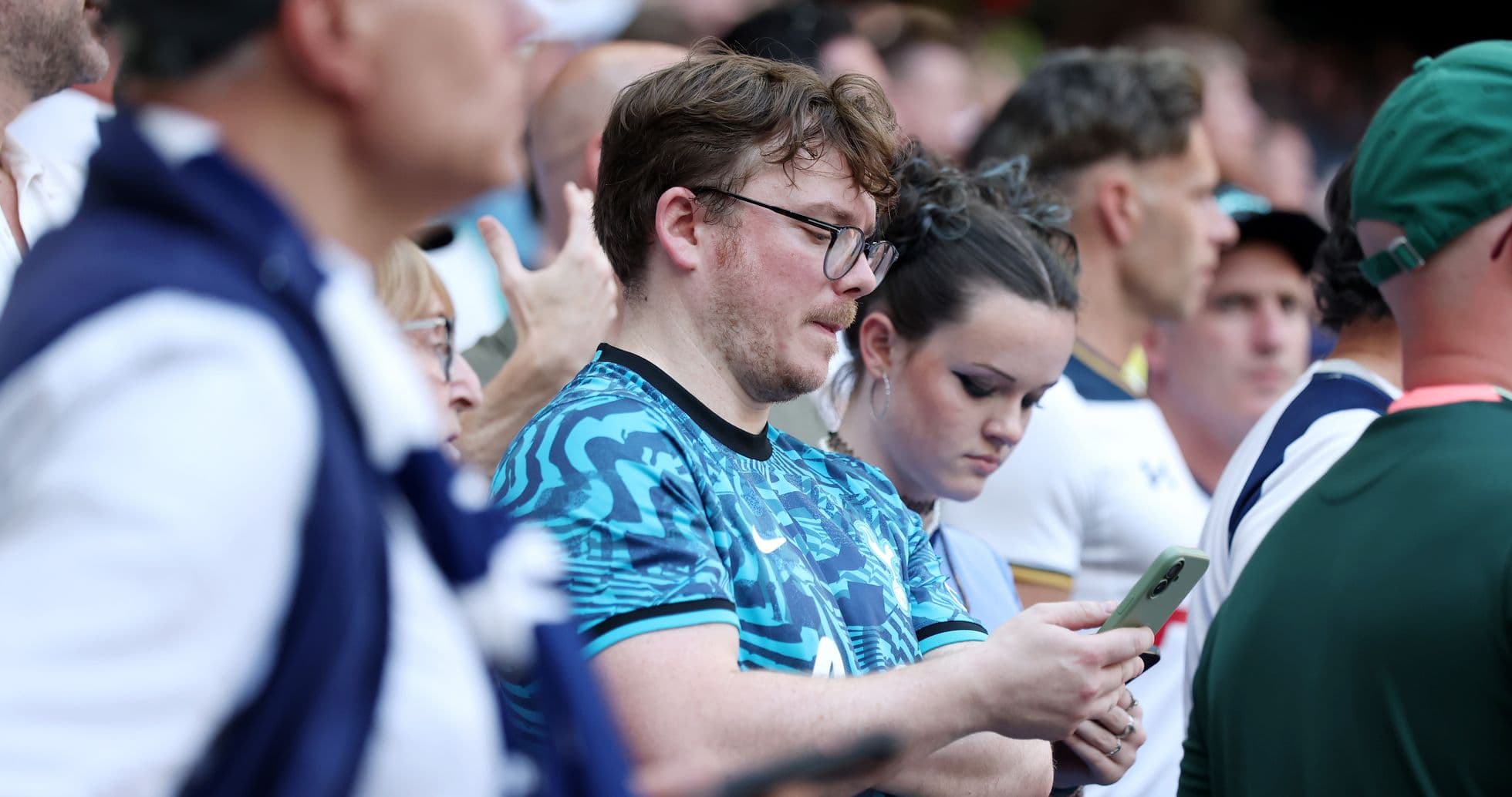 Fans watching the match, some using smartphones Fans watching the match, some using smartphones