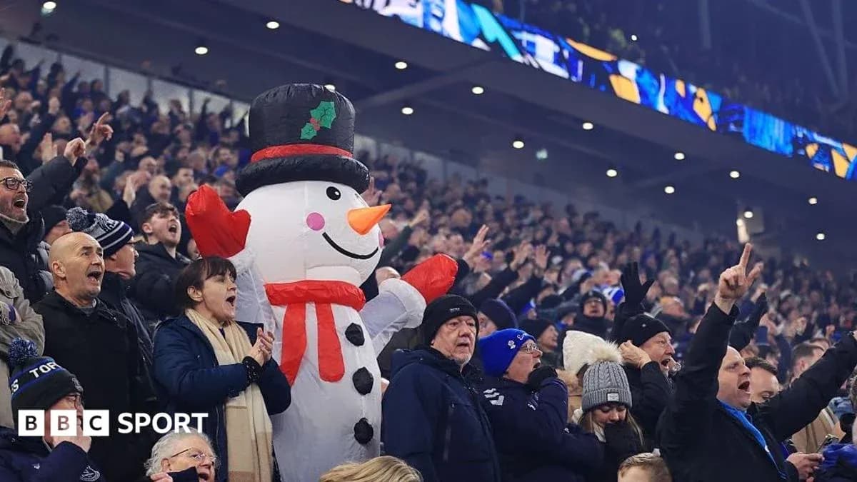 Fans celebrating with a large snowman mascot Fans celebrating with a large snowman mascot