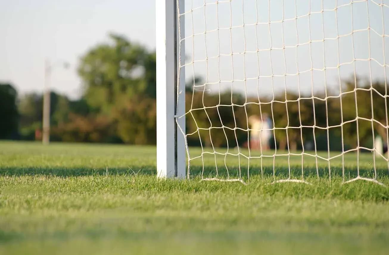 Close-up of a soccer goal net and grass Close-up of a soccer goal net and grass