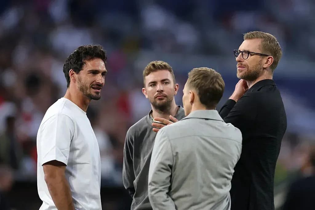 Four men talking on the sidelines of a match Four men talking on the sidelines of a match