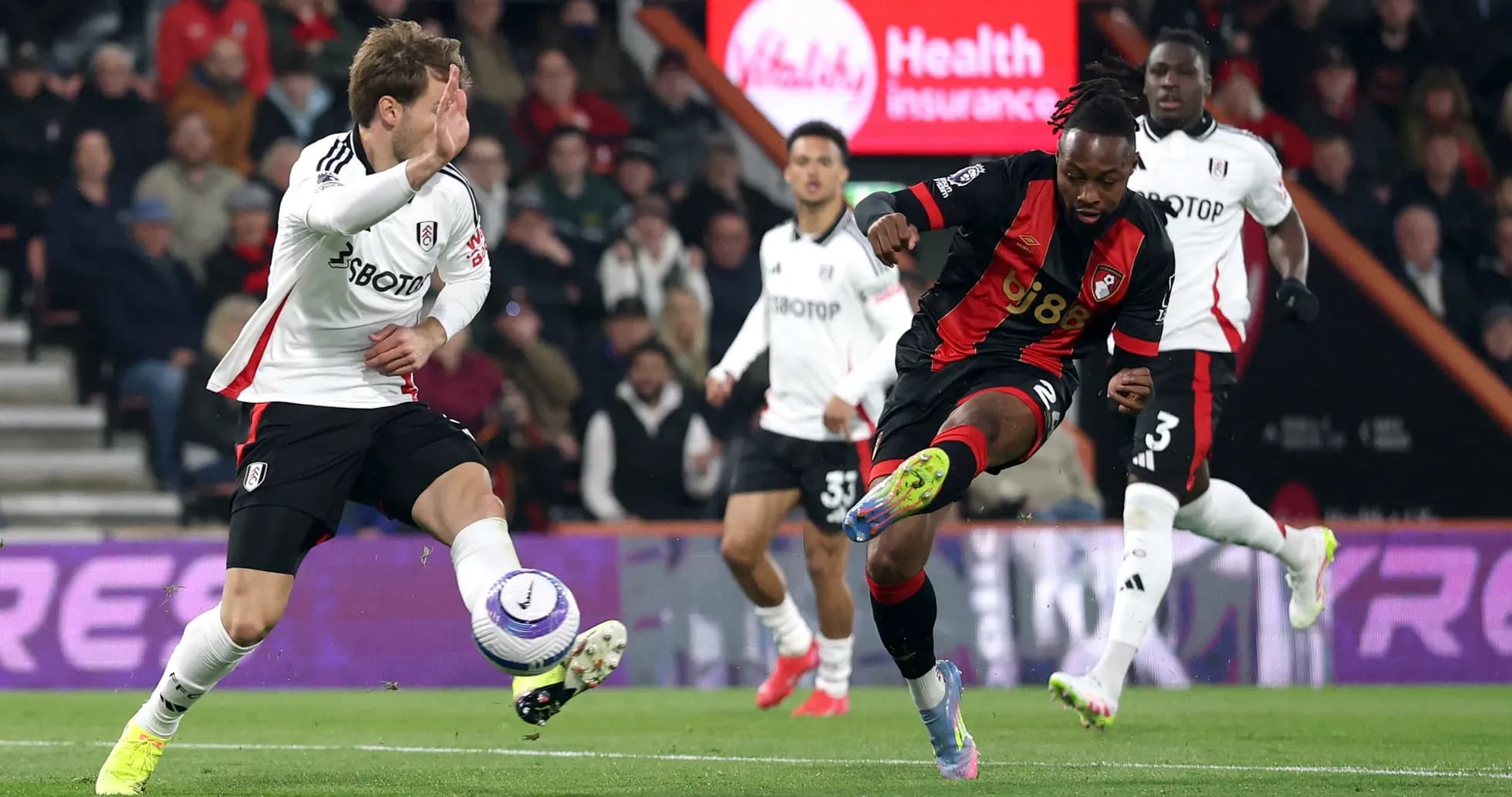 Fulham player challenging Bournemouth player for the ball Fulham player challenging Bournemouth player for the ball