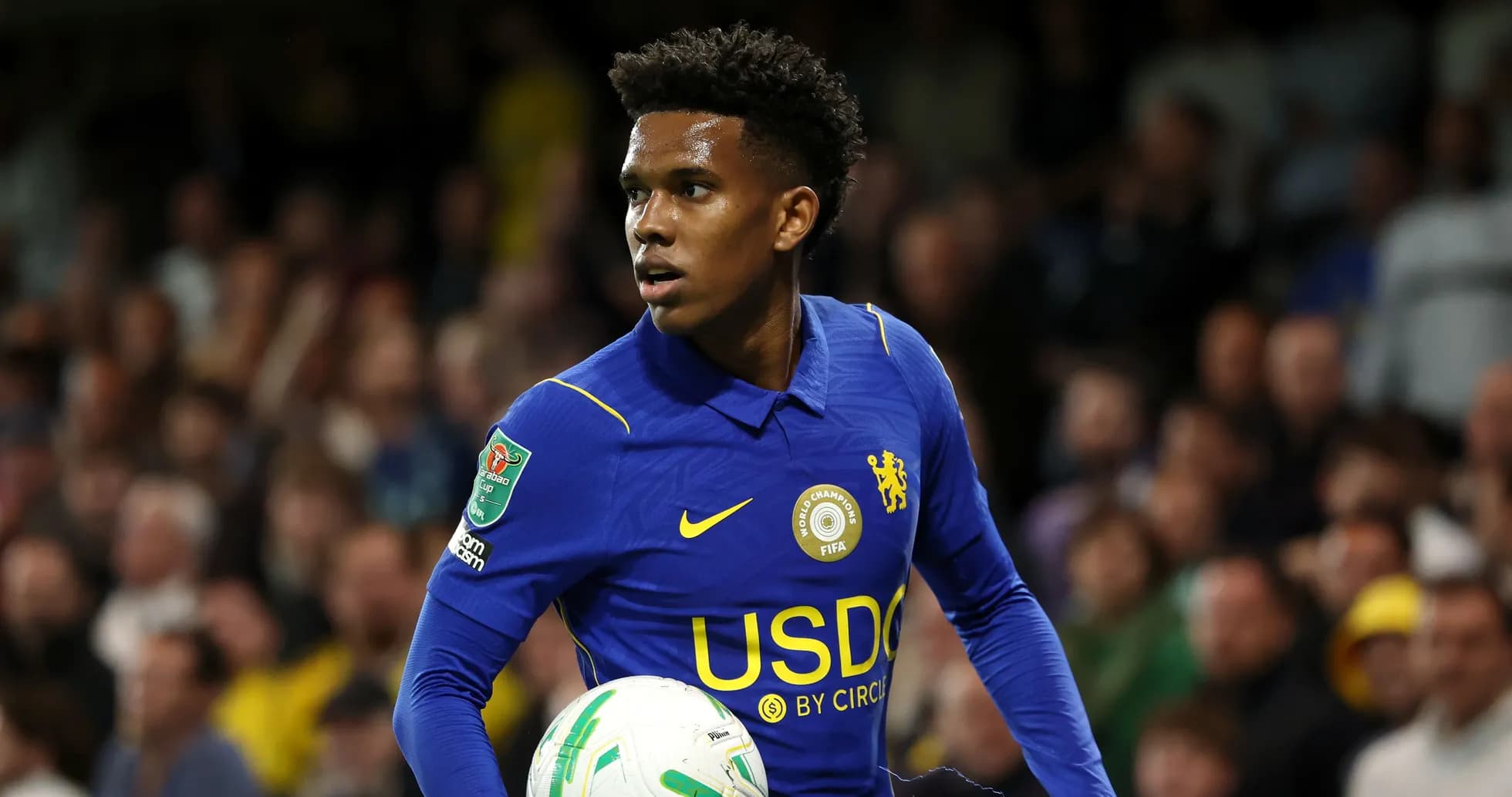 Player in blue jersey holding a football on pitch Player in blue jersey holding a football on pitch