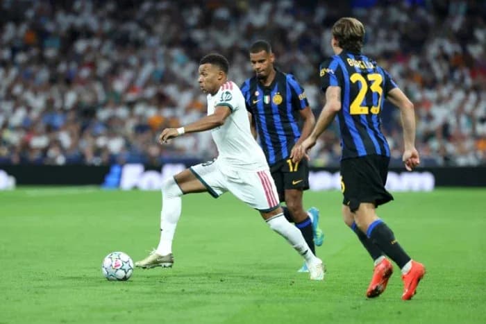 Mbappé dribbling past defenders during a match Mbappé dribbling past defenders during a match