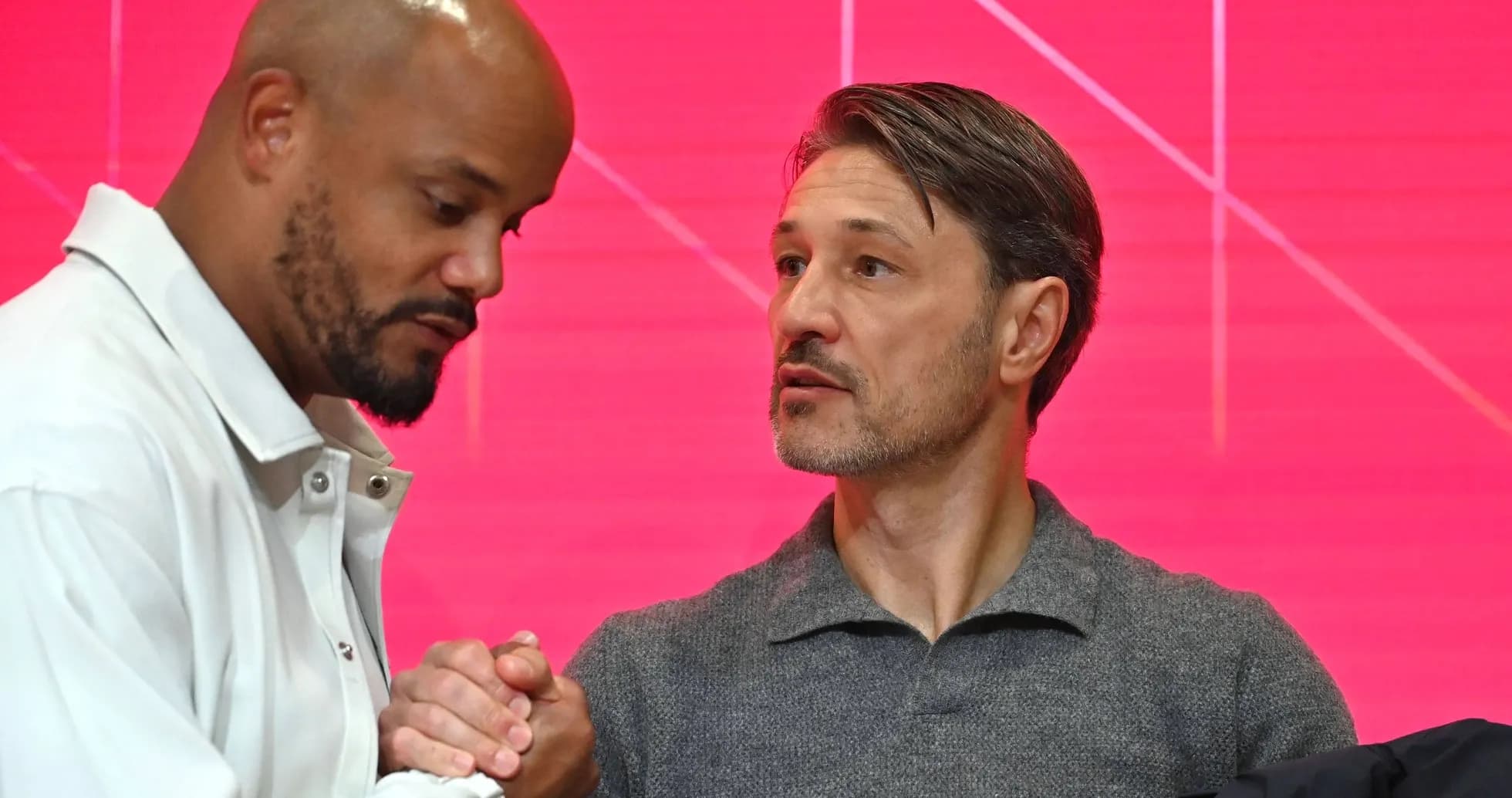 Two men shaking hands at a press event Two men shaking hands at a press event