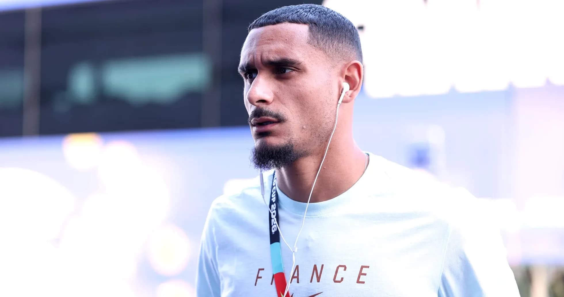 Player wearing headphones, walking in casual attire Player wearing headphones, walking in casual attire
