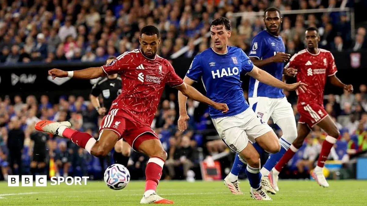Liverpool player kicking the ball against Ipswich defender Liverpool player kicking the ball against Ipswich defender