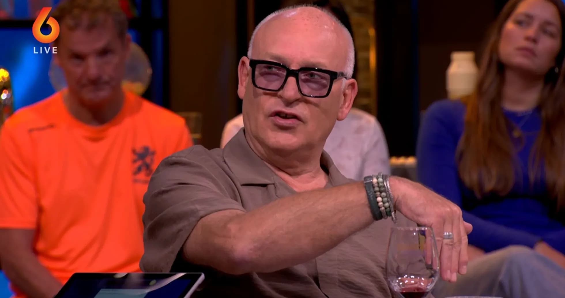 Man speaking at a talk show with audience behind Man speaking at a talk show with audience behind