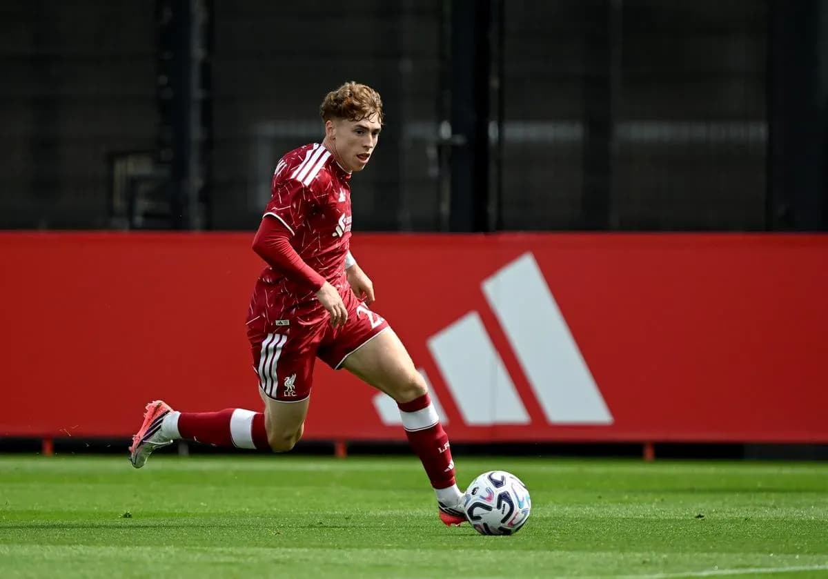 Player in red kit running with soccer ball Player in red kit running with soccer ball