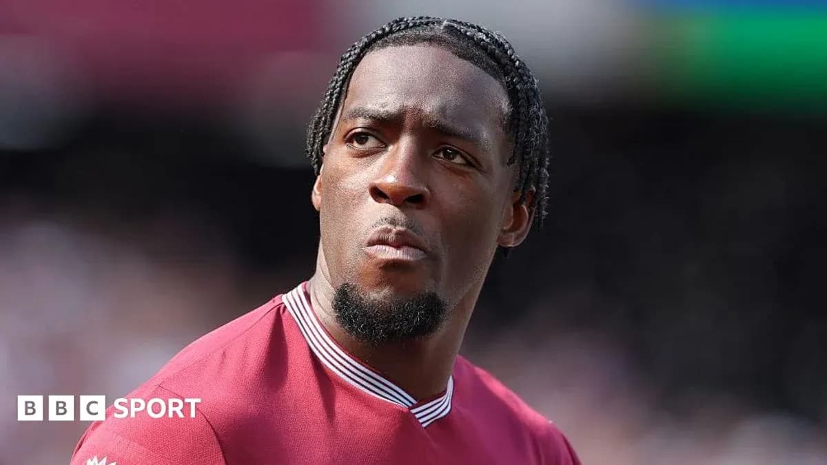 Player in maroon jersey looking focused on field Player in maroon jersey looking focused on field