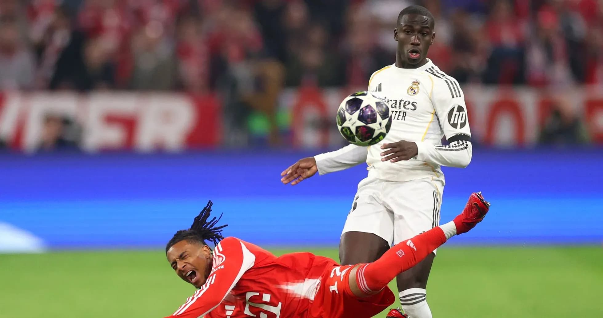 Player falling while opponent attempts to control the ball Player falling while opponent attempts to control the ball
