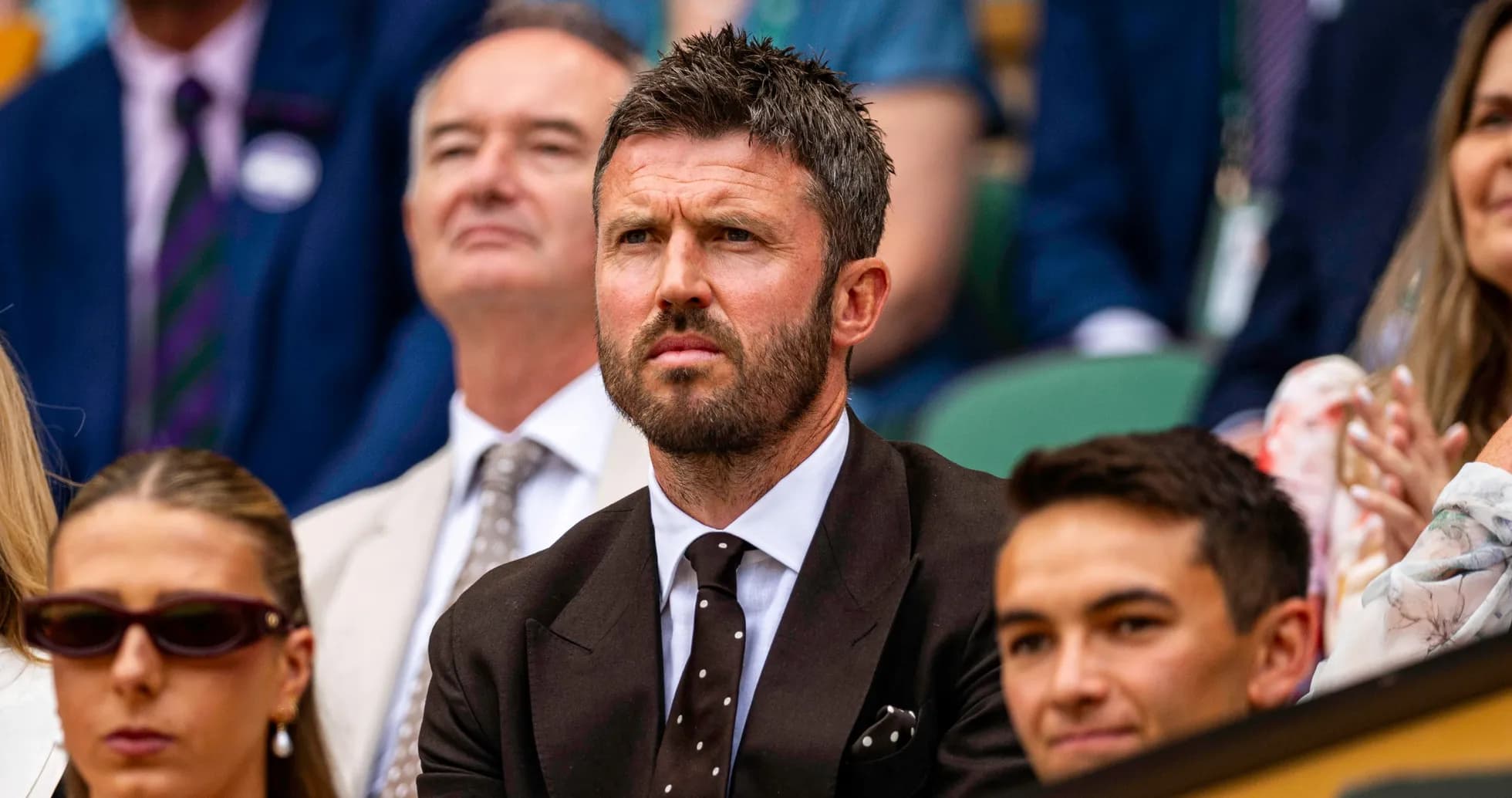 Man in suit watching tennis match in audience Man in suit watching tennis match in audience