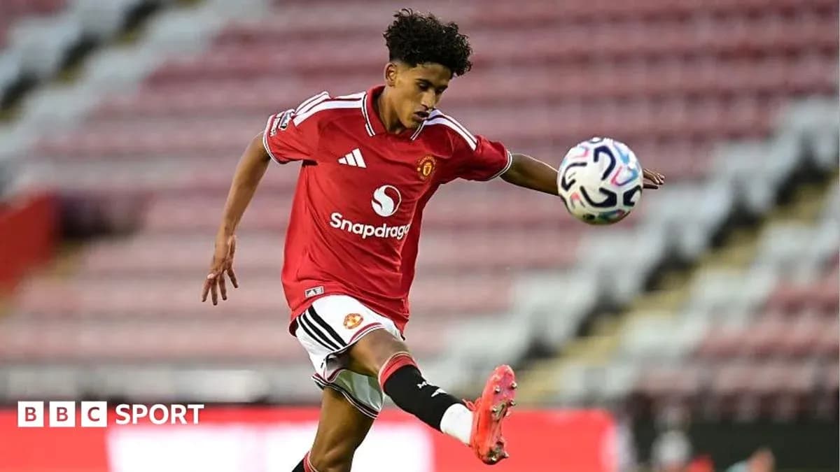 Player in Manchester United kit kicking a soccer ball Player in Manchester United kit kicking a soccer ball