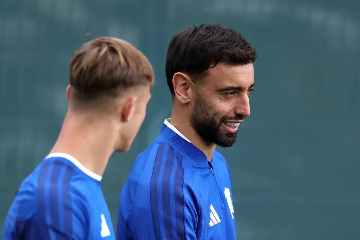 Two players in blue training kits talking outdoors Two players in blue training kits talking outdoors