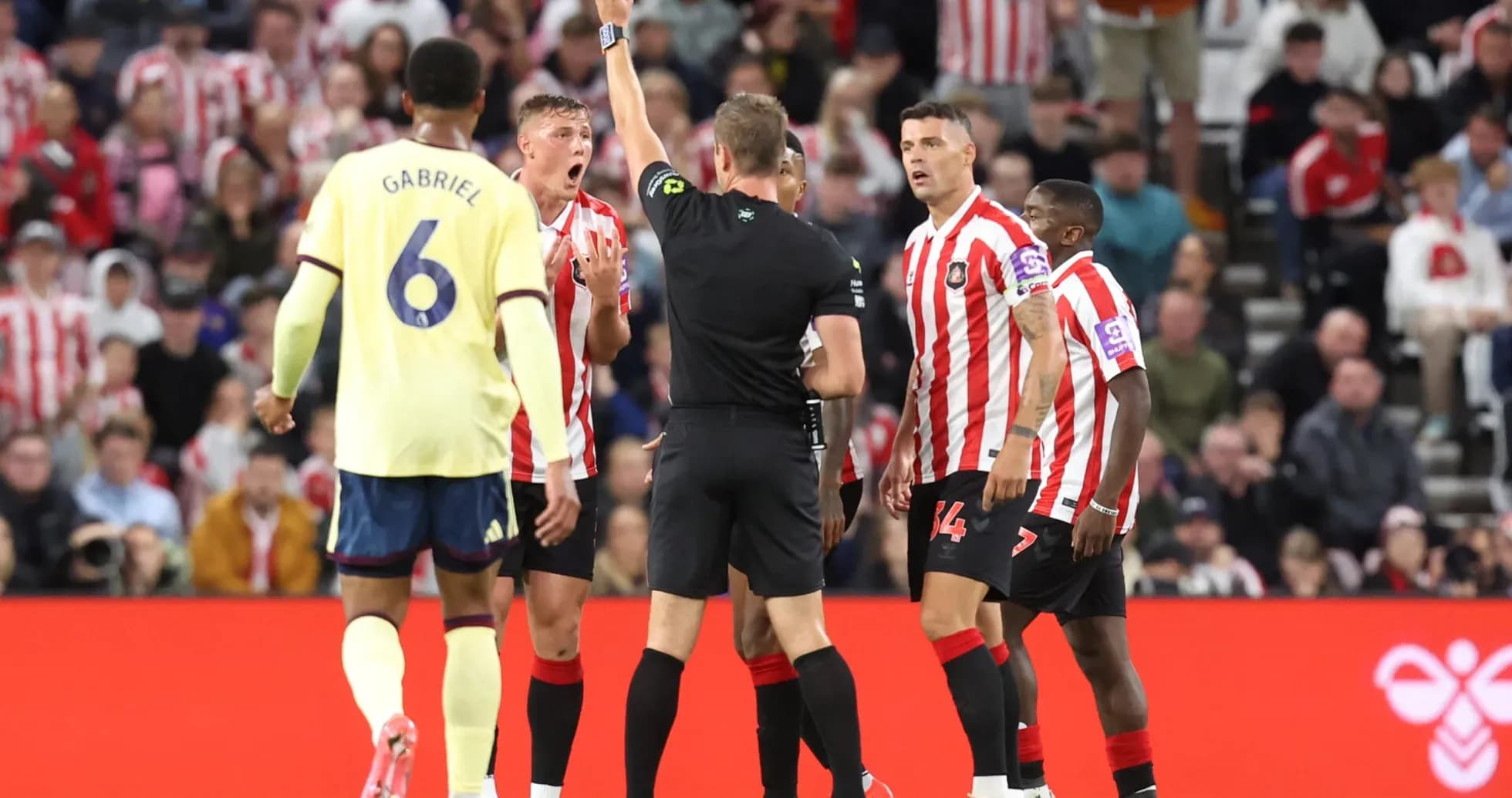 Referee showing yellow card to Sunderland player Referee showing yellow card to Sunderland player