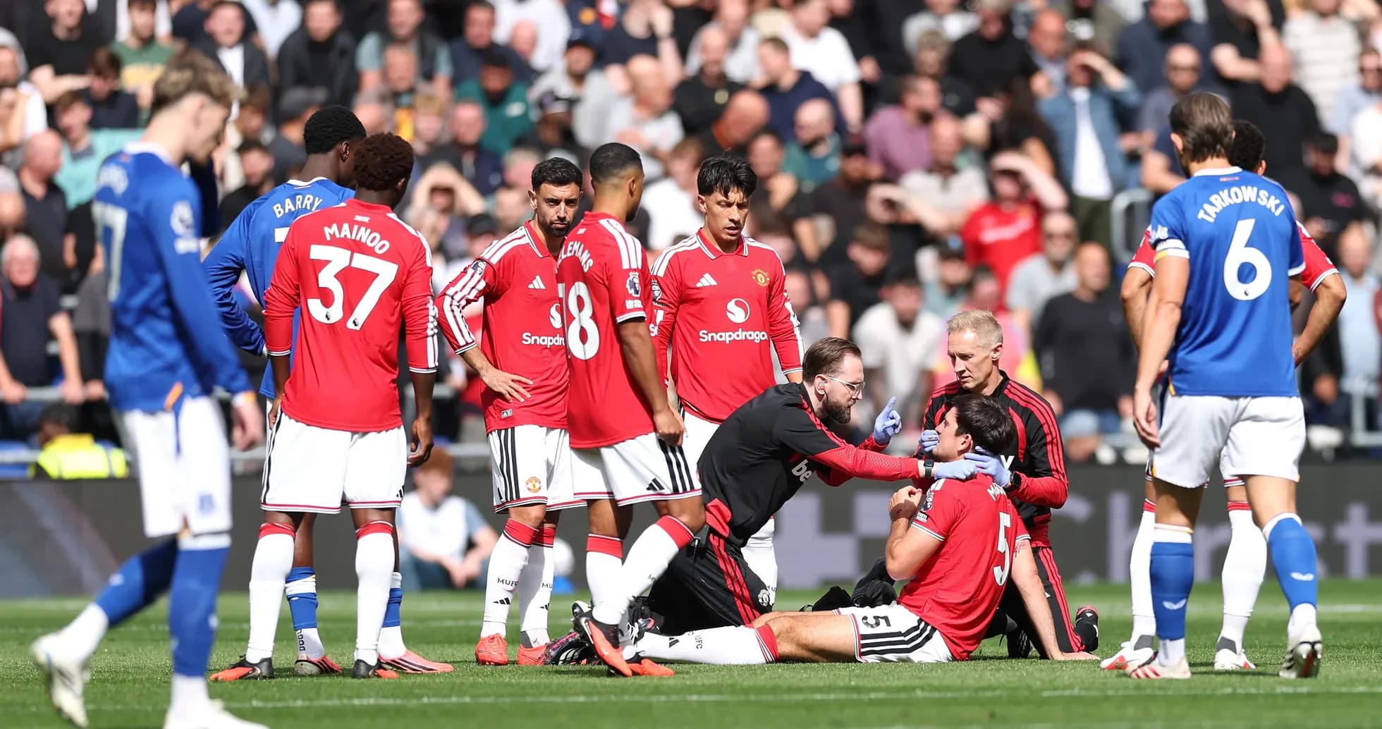 Medical staff attending to injured player on pitch Medical staff attending to injured player on pitch