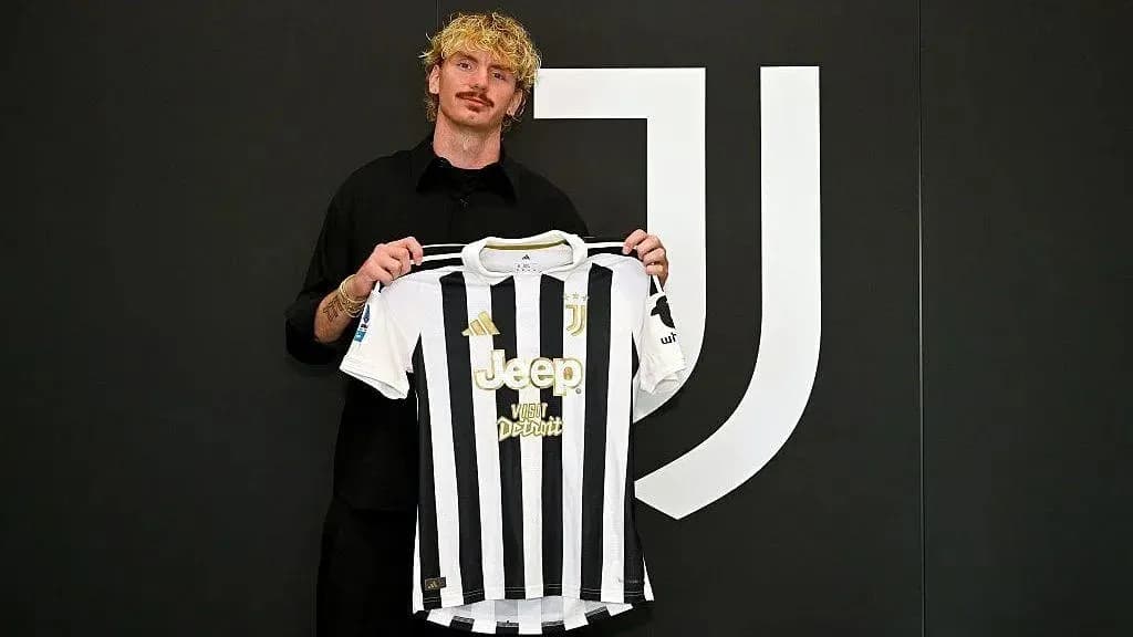 Player holding Juventus jersey during signing ceremony Player holding Juventus jersey during signing ceremony
