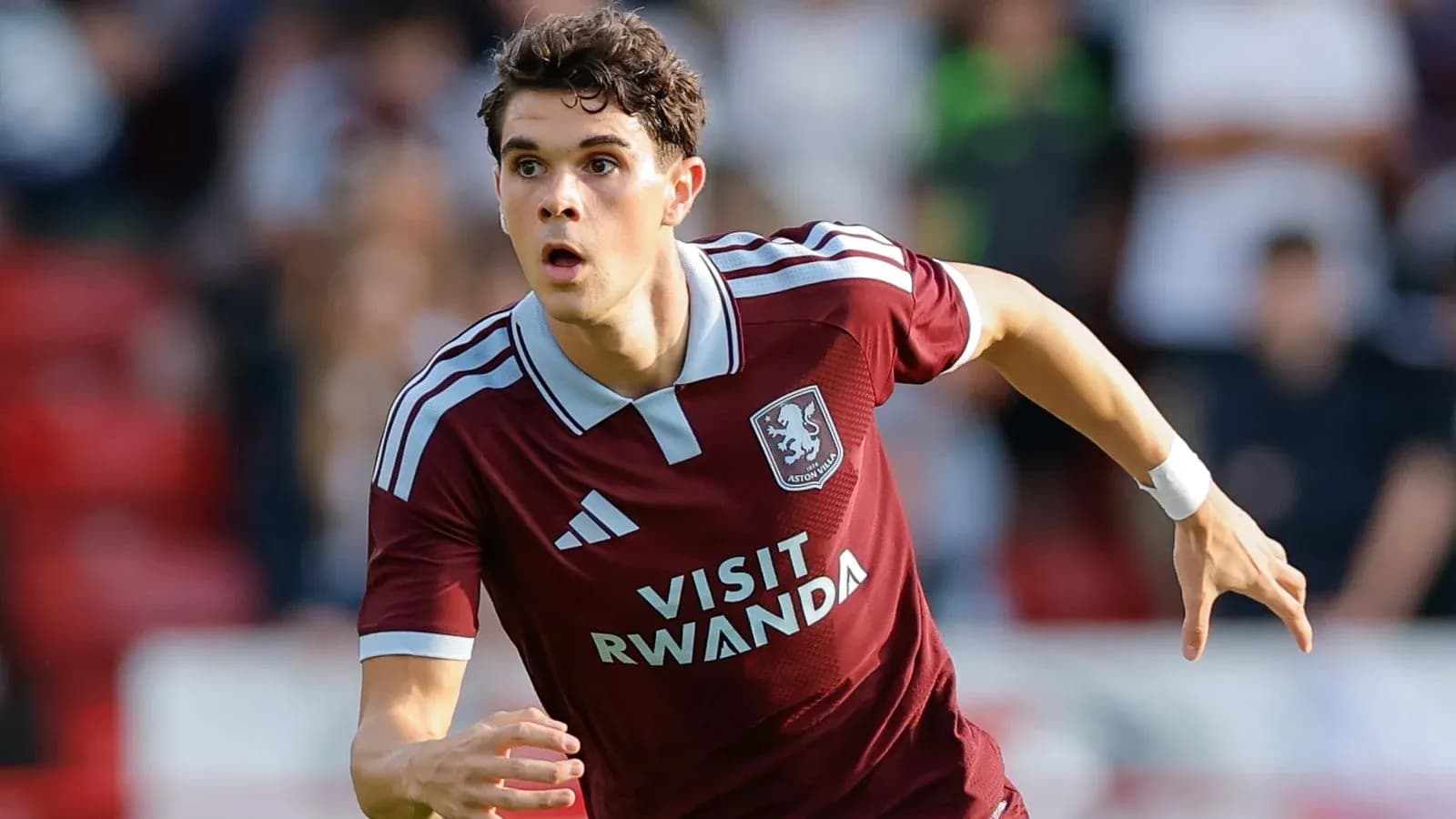 Player in maroon kit sprinting during match Player in maroon kit sprinting during match