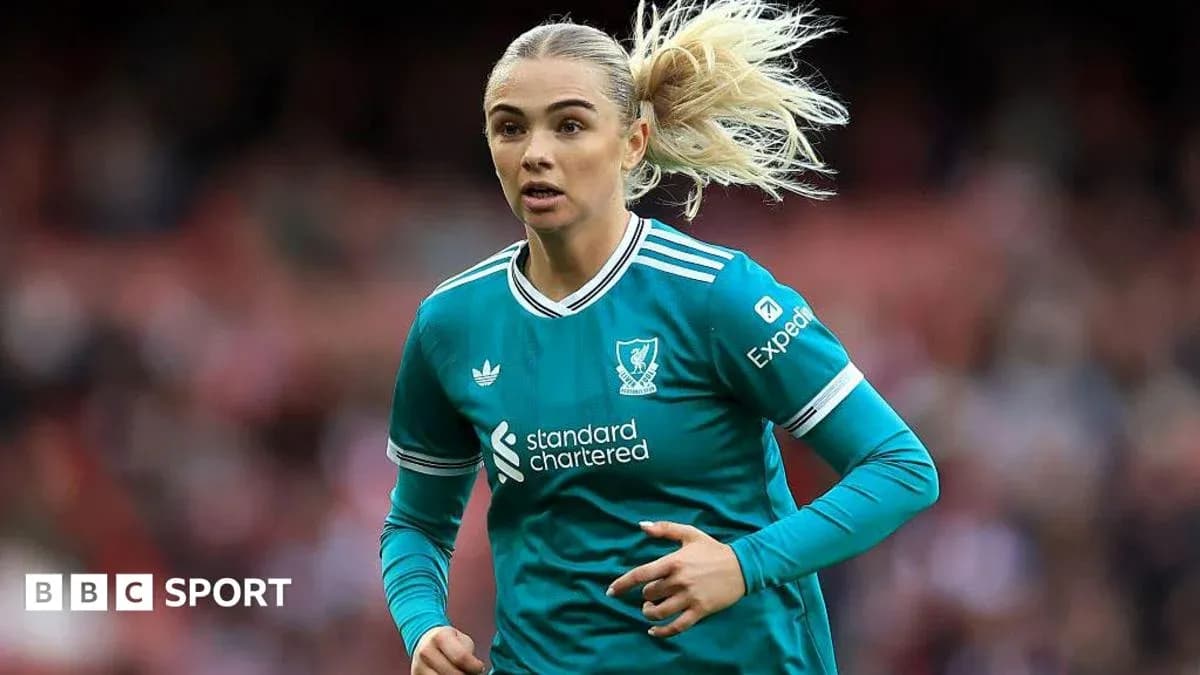 Player in teal Liverpool kit running on field Player in teal Liverpool kit running on field