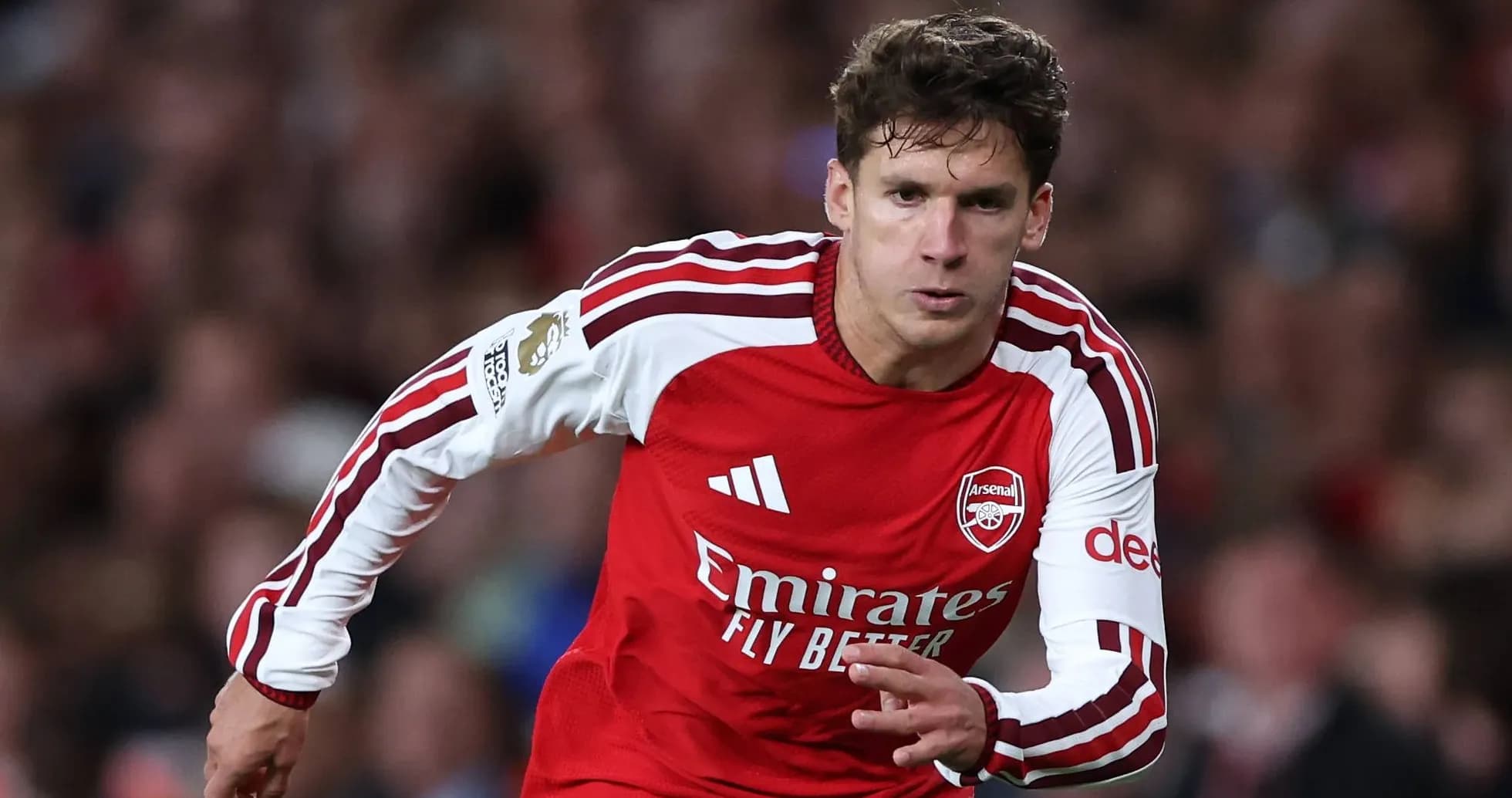 Player in red Arsenal kit sprinting on the pitch Player in red Arsenal kit sprinting on the pitch