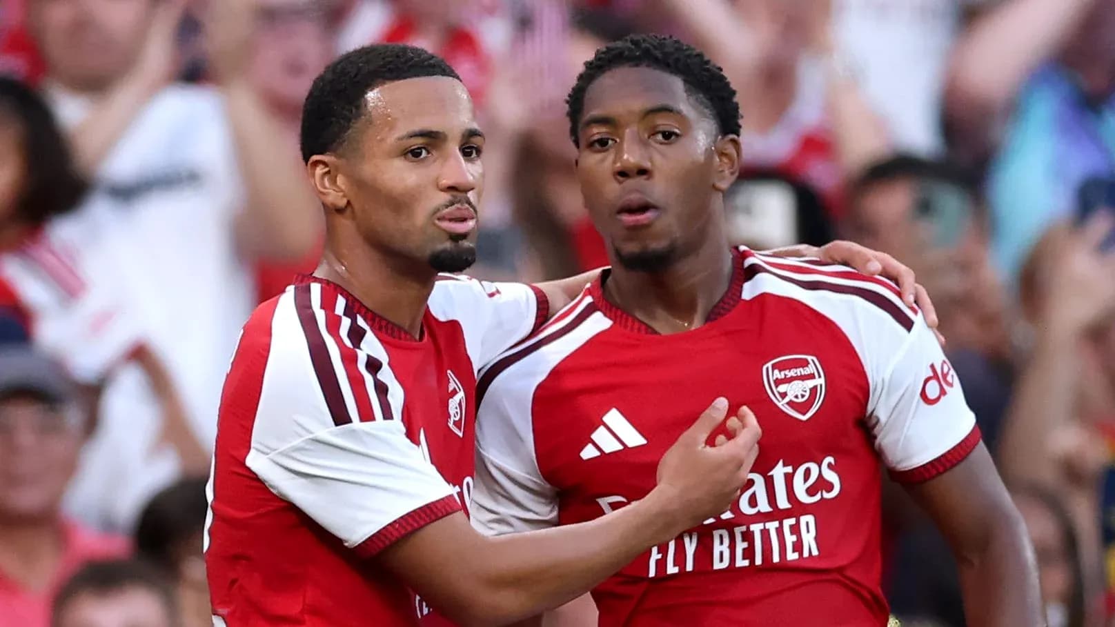 Two Arsenal players celebrating a goal together Two Arsenal players celebrating a goal together