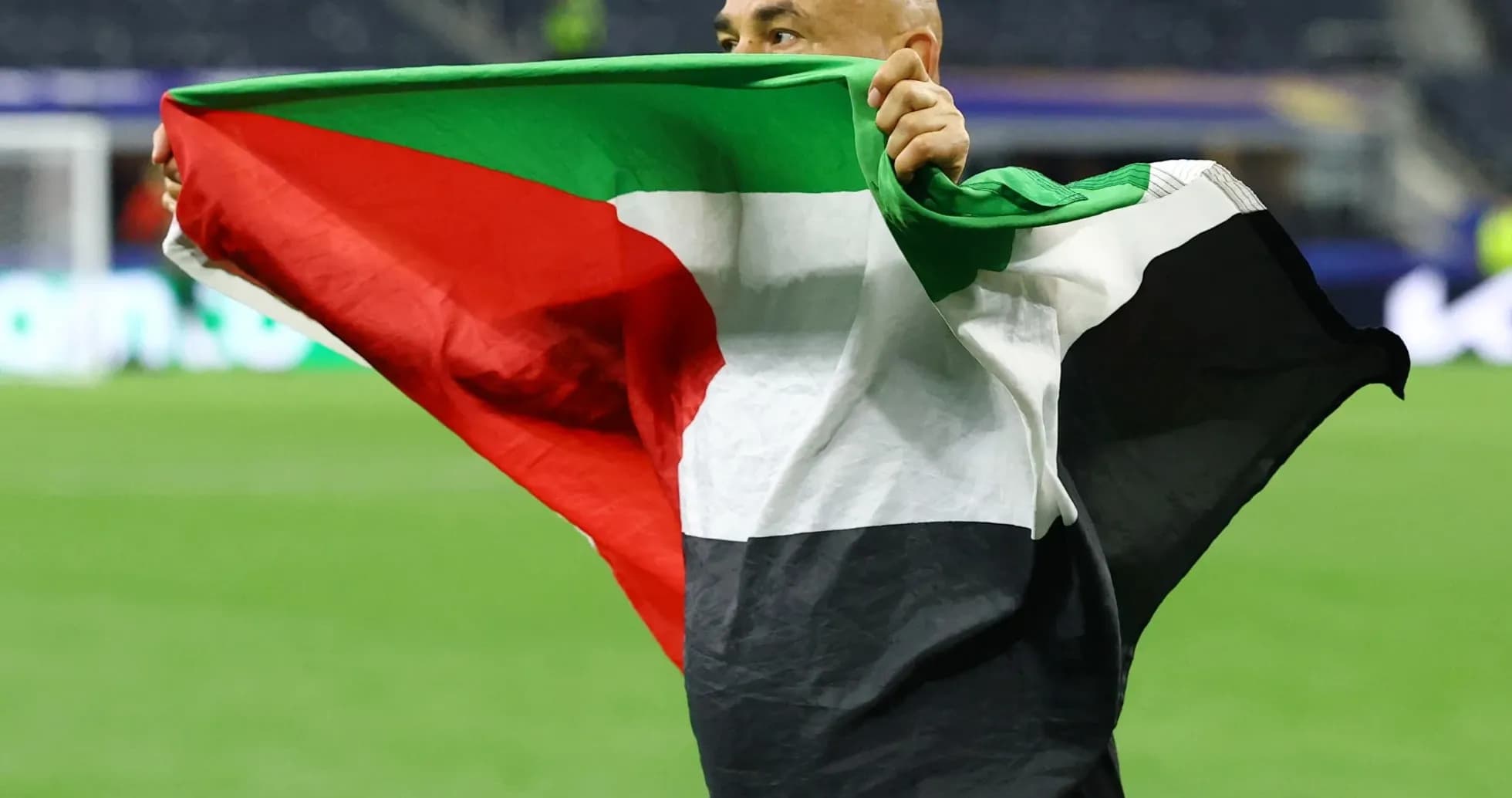 Person celebrating with a flag on the field Person celebrating with a flag on the field